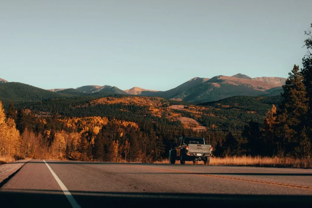 A pickup truck driving a scenic mountain road