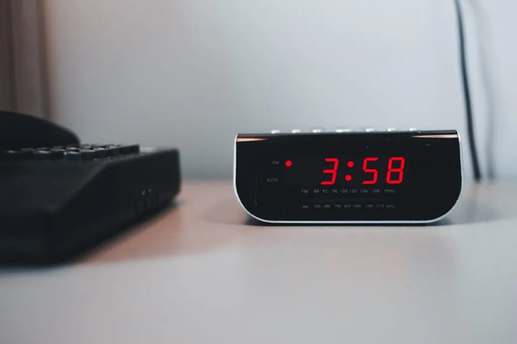 Red LED digital alarm clock on a nightstand