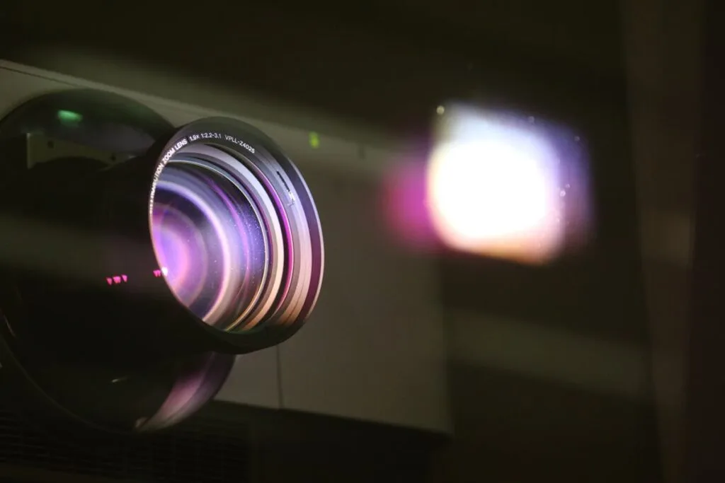 Projector lens projecting a beam of light in a dark room